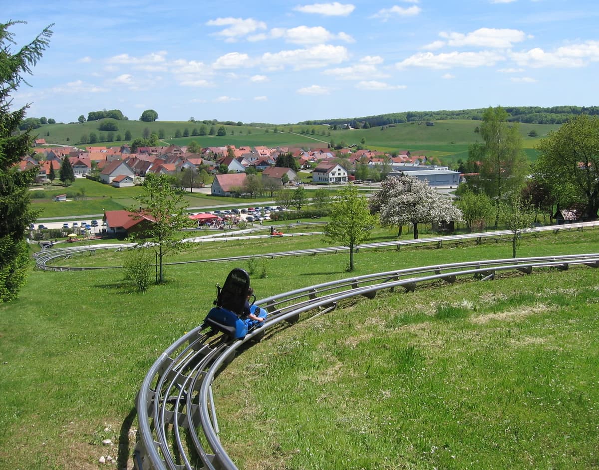 Heller blauer Himmel mit weißen Wolken, die sanft über die Landschaft ziehen.